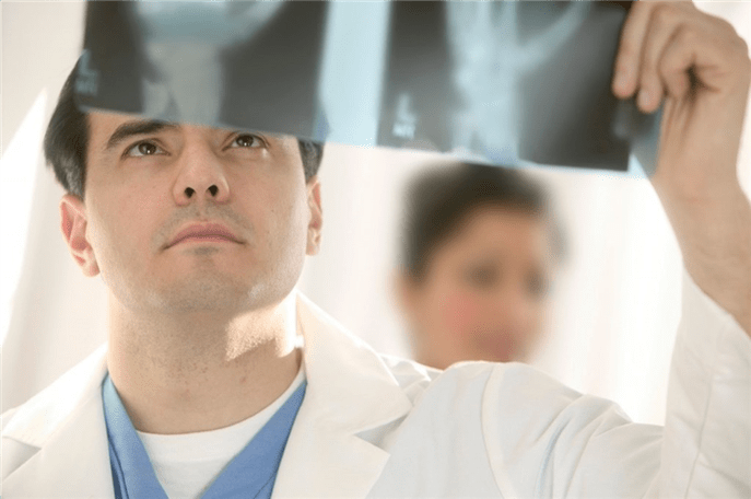 médico examina uma foto da articulação do quadril com artrose